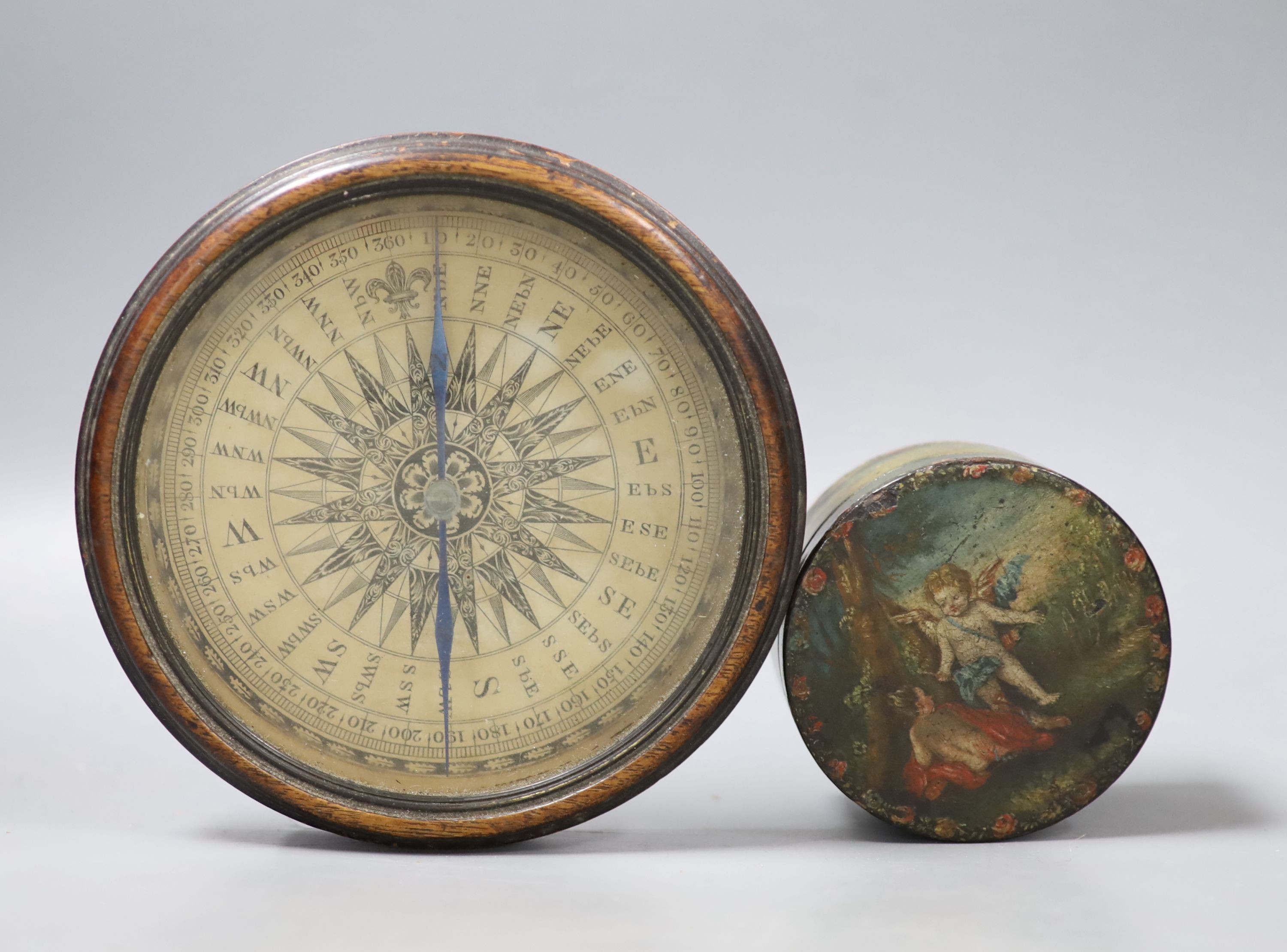 A 19th century circular papier mache box and cover decorated with cherubs and a compass from a library globe, diameter 14cm